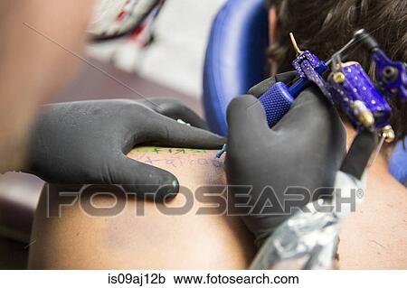 Close up of tattooist giving customer their first tattoo View Large Photo Image Stock Image - Close up of tattooist giving customer their first tattoo. Fotosearch