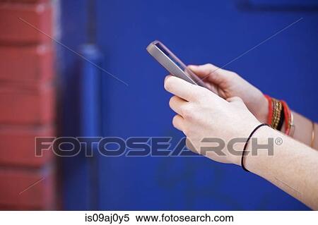 Stock Photography - Close-up of women's hands using mobile phone. Fotosearch