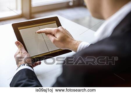 Close up of young man in office using touchscreen on digital tablet View Large Photo Image Stock Image - Close up of young man in office using touchscreen on digital tablet. Fotosearch