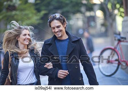 Couple arm in arm running across city street View Large Photo Image Stock Image - Couple arm in arm running across city street. Fotosearch
