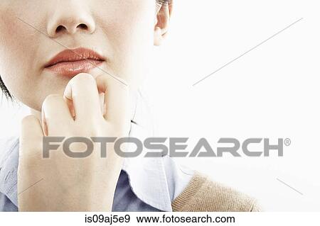 Stock Photo - Cropped close up of hand on young woman's chin. Fotosearch