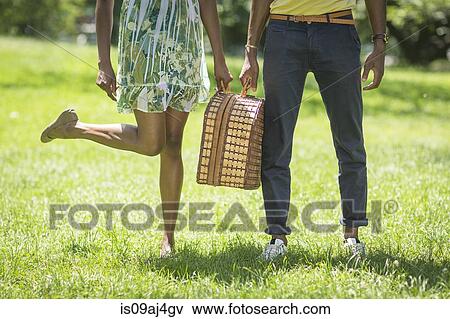 Cropped image of young couple with picnic basket in park View Large Photo Image Stock Photo - Cropped image of young couple with picnic basket in park. Fotosearch