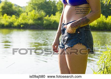 Cropped shot of young woman smoking cigarette on canal bank, Delaware Canal State Park, New Hope, Pennsylvania, USA View Large Photo Image Stock Image - Cropped shot of young woman smoking cigarette on canal bank, Delaware Canal State Park, New Hope, Pennsylvania, USA. Fotosearch