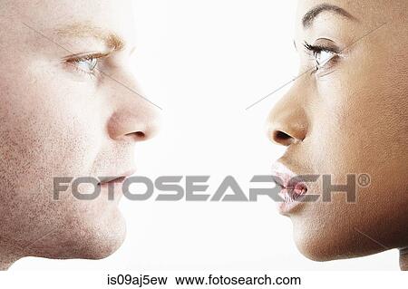 Cropped studio portrait of young couple face to face in profile View Large Photo Image Stock Photo - Cropped studio portrait of young couple face to face in profile. Fotosearch