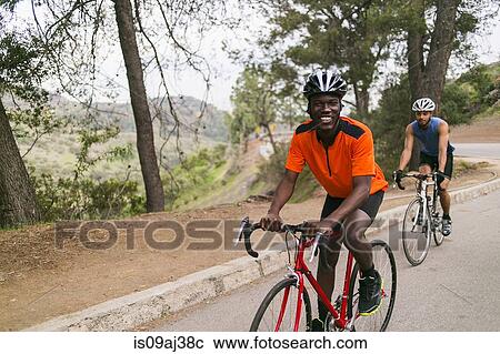 Stock Image - Cyclists on uphill road. Fotosearch