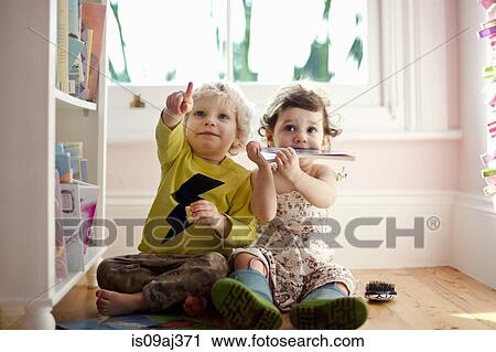Stock Image - Female and male toddler friends pointing and looking up. Fotosearch