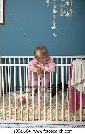 Female toddler climbing over side of crib View Large Photo Image Picture - Female toddler climbing over side of crib. Fotosearch