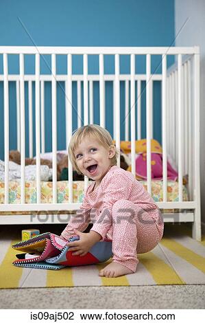 Female toddler playing with textile picture book in bedroom View Large Photo Image Stock Image - Female toddler playing with textile picture book in bedroom. Fotosearch