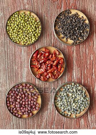 Stock Image - Five dishes containing dried food: Mung Beans, Black Barley, Pequin Chiles, Adzuki Beans, French Green Lentils. Fotosearch