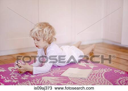 Four year old boy lying on rug gazing at snow globe View Large Photo Image Stock Image - Four year old boy lying on rug gazing at snow globe. Fotosearch
