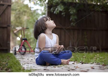 Four year old girl sitting on garden path gazing upward View Large Photo Image Stock Photograph - Four year old girl sitting on garden path gazing upward. Fotosearch