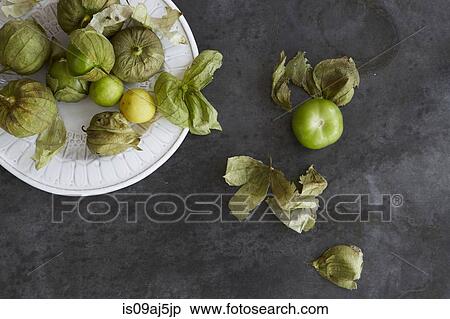 Stock Photography - Fresh tomatillos on a plate and zinc metal surface. Fotosearch
