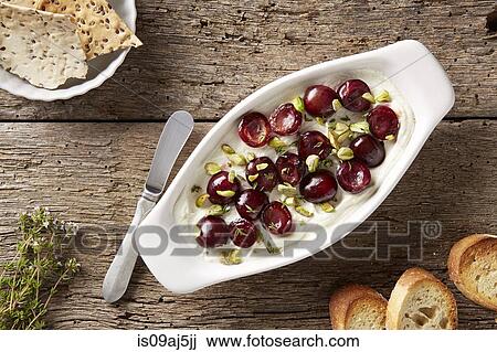Goats cheese with sauteed cherries, pistachios and fresh thyme. Served with bread and flax seed crackers View Large Photo Image Stock Image - Goats cheese with sauteed cherries, pistachios and fresh thyme. Served with bread and flax seed crackers. Fotosearch