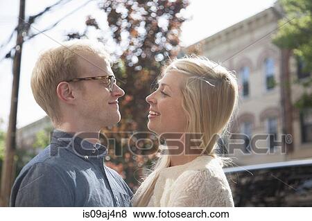 Stock Photo - Happy young couple face to face on street. Fotosearch