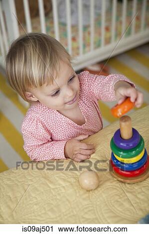 Stock Image - High angle view of female toddler playing with stacking toy. Fotosearch