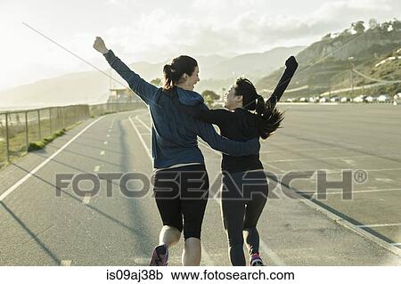 Stock Image - Joggers cheering on road. Fotosearch
