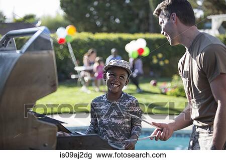 Male soldier and boy barbecuing at homecoming party View Large Photo Image Stock Image - Male soldier and boy barbecuing at homecoming party. Fotosearch