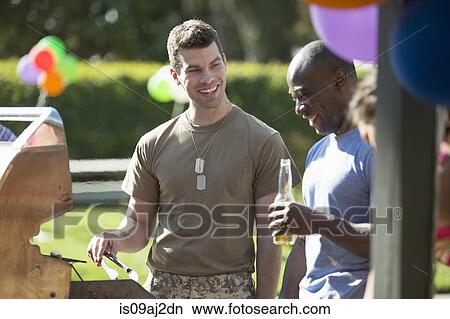 Male soldier barbecuing with friends at homecoming party View Large Photo Image Picture - Male soldier barbecuing with friends at homecoming party. Fotosearch