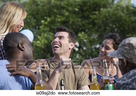 Picture - Male soldier celebrating with family and friends at homecoming party. Fotosearch