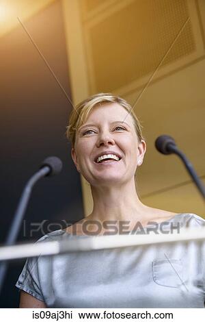 Stock Image - Mature businesswoman speaking in conference room. Fotosearch
