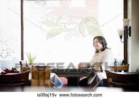 Mature woman having a herbal tea in cafe window seat View Large Photo Image Stock Photo - Mature woman having a herbal tea in cafe window seat. Fotosearch