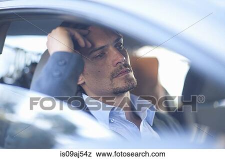 Mid adult businessman driving in traffic congestion View Large Photo Image Stock Photo - Mid adult businessman driving in traffic congestion. Fotosearch