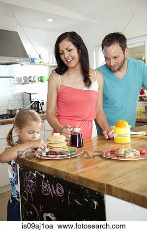 Mid adult parents watching daughter tempted by pancakes at breakfast bar View Large Photo Image Stock Image - Mid adult parents watching daughter tempted by pancakes at breakfast bar. Fotosearch