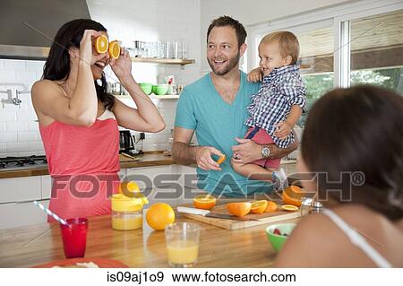 Mother making a face with oranges for her family at breakfast bar View Large Photo Image Stock Photo - Mother making a face with oranges for her family at breakfast bar. Fotosearch