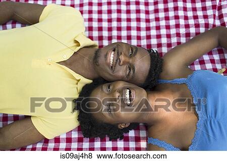 Overhead portrait of young couple lying on picnic blanket on opposite sides View Large Photo Image Stock Photo - Overhead portrait of young couple lying on picnic blanket on opposite sides. Fotosearch