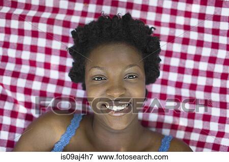 Overhead portrait of young woman lying on picnic blanket View Large Photo Image Stock Photo - Overhead portrait of young woman lying on picnic blanket. Fotosearch