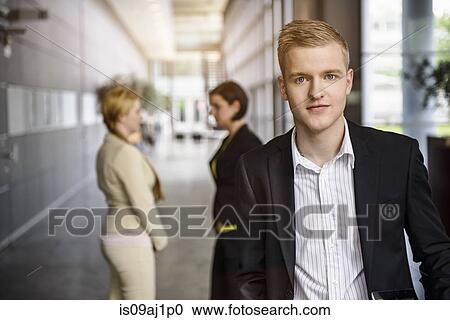 Portrait of ambitious young businessman in office corridor View Large Photo Image Stock Image - Portrait of ambitious young businessman in office corridor. Fotosearch