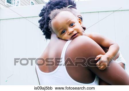 Portrait of baby boy looking over mother's shoulder View Large Photo Image Stock Image - Portrait of baby boy looking over mother's shoulder. Fotosearch