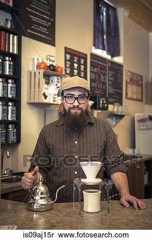 Stock Photography - Portrait of barista serving coffee on cafe counter. Fotosearch