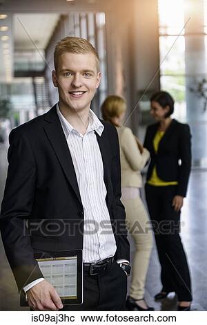 Stock Image - Portrait of businessman with digital tablet in office. Fotosearch