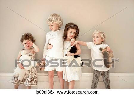 Portrait of four young children in a row, one crying View Large Photo Image Stock Photo - Portrait of four young children in a row, one crying. Fotosearch