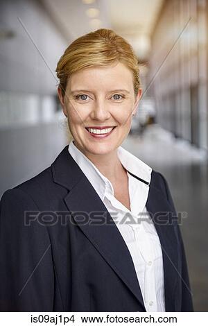 Portrait of happy mature businesswoman in office corridor View Large Photo Image Picture - Portrait of happy mature businesswoman in office corridor. Fotosearch
