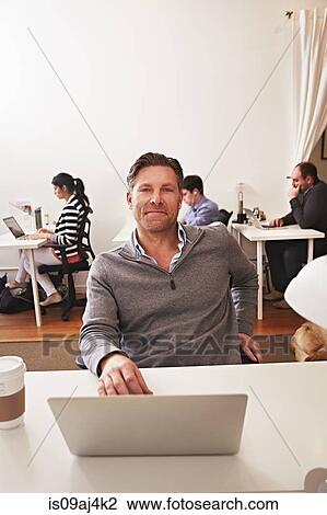 Portrait of man in office with laptop View Large Photo Image Stock Image - Portrait of man in office with laptop. Fotosearch