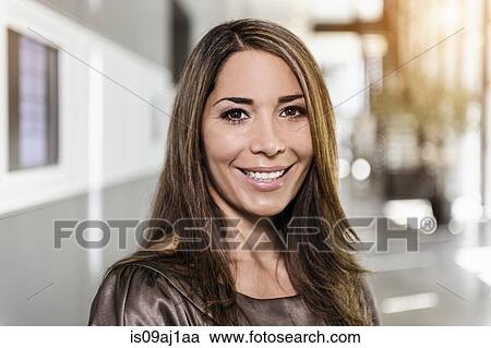 Stock Image - Portrait of mid adult businesswoman in office. Fotosearch