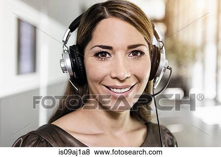 Stock Photo - Portrait of mid adult businesswoman using telephone headset. Fotosearch