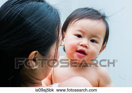 Stock Image - Portrait of mid adult mother and baby boy. Fotosearch