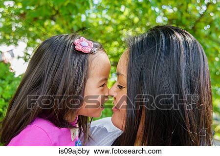 Stock Photo - Portrait of mid adult mother and girl toddler nose to nose. Fotosearch