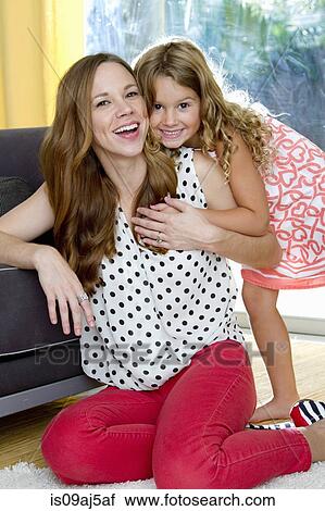 Portrait of mid adult mother and daughter sharing a hug View Large Photo Image Stock Image - Portrait of mid adult mother and daughter sharing a hug. Fotosearch