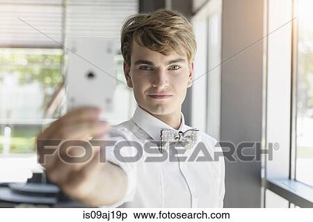 Portrait of young businessman holding up an ace playing card in office View Large Photo Image Stock Photography - Portrait of young businessman holding up an ace playing card in office. Fotosearch