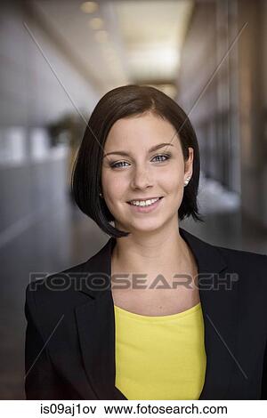 Portrait of young businesswoman in office corridor View Large Photo Image Stock Photo - Portrait of young businesswoman in office corridor. Fotosearch