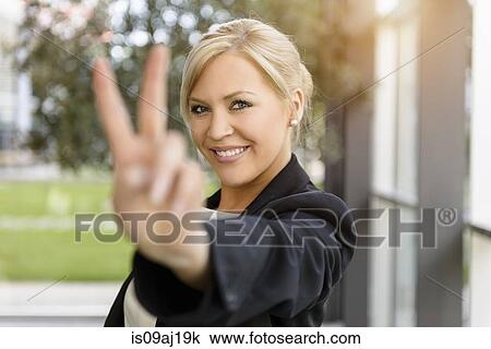 Portrait of young businesswoman making victory sign View Large Photo Image Stock Image - Portrait of young businesswoman making victory sign. Fotosearch