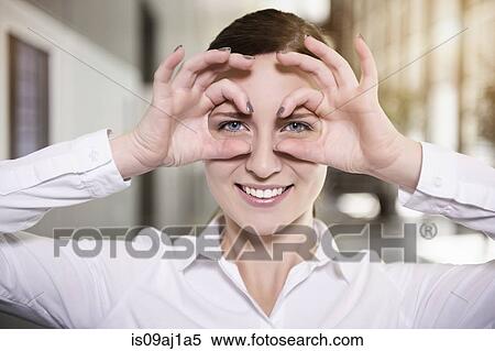 Portrait of young businesswoman making face with hand spectacles View Large Photo Image Stock Photography - Portrait of young businesswoman making face with hand spectacles. Fotosearch