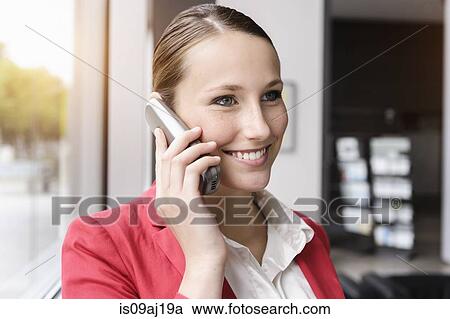 Stock Image - Portrait of young businesswoman talking on cellphone. Fotosearch