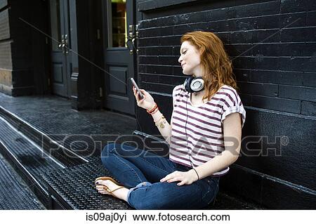 Portrait of young woman using mobile phone View Large Photo Image Stock Image - Portrait of young woman using mobile phone. Fotosearch