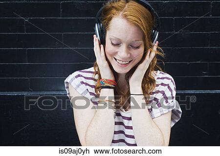 Portrait of young woman wearing headphones View Large Photo Image Stock Image - Portrait of young woman wearing headphones. Fotosearch