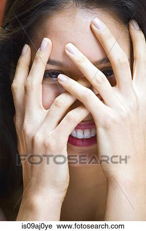 Portrait of young woman with hands covering face View Large Photo Image Stock Image - Portrait of young woman with hands covering face. Fotosearch